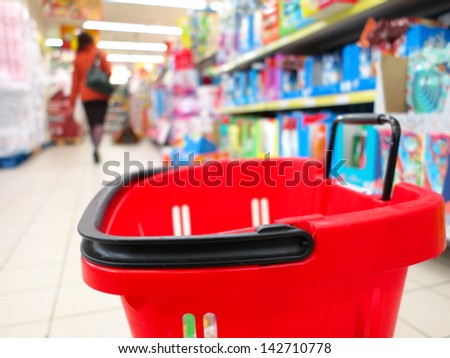 view of a red shopping basket with grocery items at supermarket