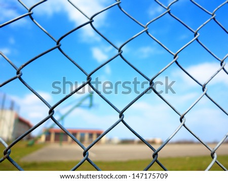 Metal mesh wire fence with blur basketball court background