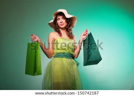 young spring woman with green shopping bags on green background