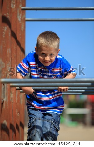 child in playground kid in action boy play on leisure equipment climbing