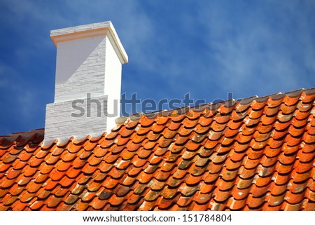 The old roofing tiles red clay house roof with chimney sky background