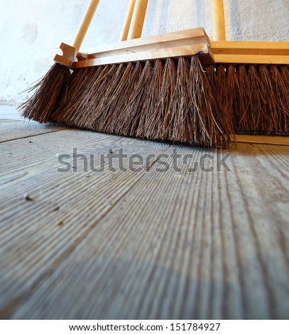 Close up large brooms for house work on old wooden floor of country house. Sweeping