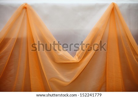 Orange curtain cloth and white wall decoration detaill. Close up table set for wedding