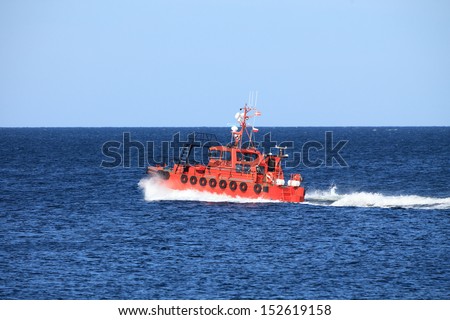 pilot boat orange tugboat at the sea monitors ships. Coastal safety, salvage and rescue
