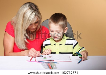 mother and son drawing together, mom helping with homework daycare brown background
