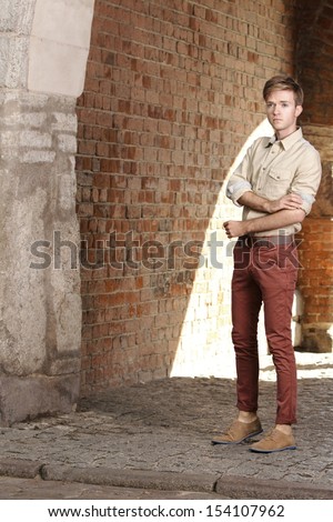 Full length young handsome man fashion model casual style posing on street of old town Gdansk Poland Europe