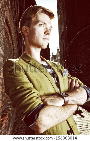 Young handsome man fashion model casual style posing on street of old town Gdansk Poland Europe