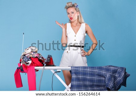 pin up girl retro style portrait woman ironing posing housewife with iron blue background