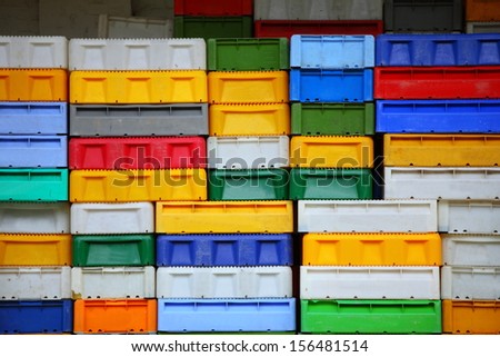 colorful boxes plastic crates background. Packing containers piles for fish storage of catch.