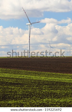 Protection of nature. Wind turbines eco power generator for renewable energy production. Alternative green clean energy, ecology. Cloudy sky meadow.