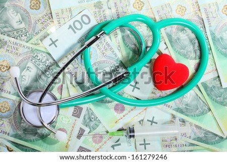 medical treatment and high cost for a good health care service concept: stethoscope red heart money polish zloty paper banknotes