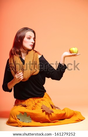 Fall. Fashion woman in autumn color girl in full length with apple long false orange eye-lashes