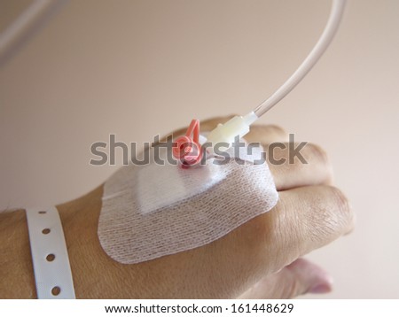Arm of a male patient in the hospital with an iv intravenous drip