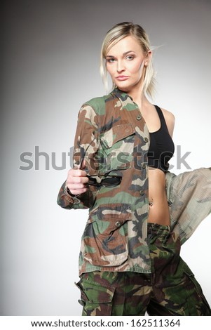 woman in military clothes army girl on gray background.