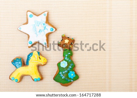 Homemade gingerbread cake pony christmas tree and star with icing and colorful decoration on brown. Holiday handmade decoration concept.