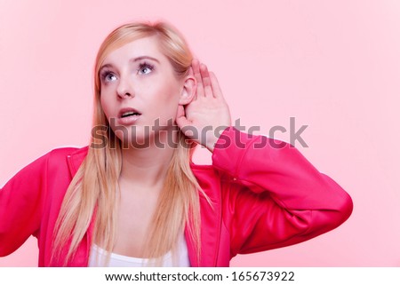 Sport fit  fitness woman with hand to ear listening pink background. Gossip
