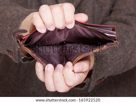 Broke businessman showing brown leather empty wallet. Business concept- finance and poor economy.
