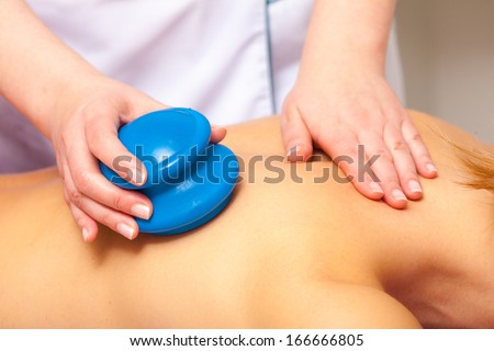 Day-spa. Young woman relaxing in healthy spa salon. Girl having cupping-glass massage. Bodycare and alternative therapy.