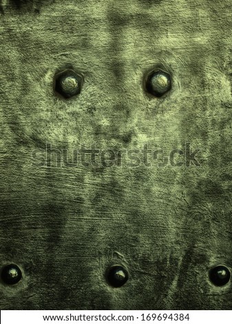 Closeup of grunge green metal plate with rivets and screws as background or texture. Square format.