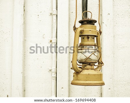 Street aged vintage kerosene oil lamp hanging outside