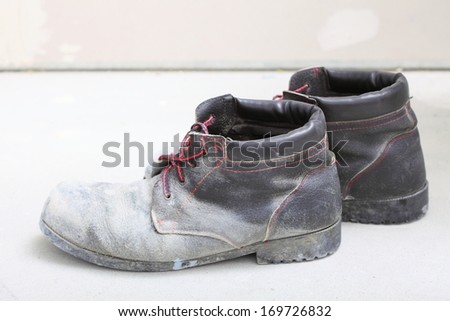 pair of old dirty work boots in construction site