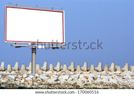 Blank white billboard with space for your advertisement on a background of breakwater and sky