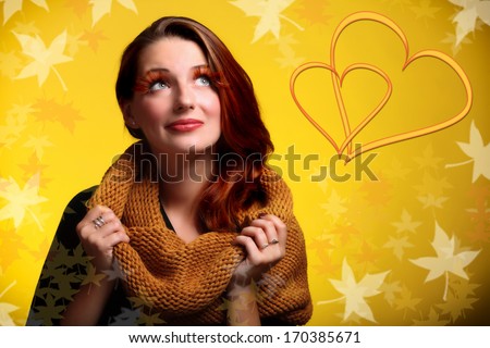 Fashionable girl in love young woman with autumnal creative makeup dreaming about love. Golden background with leaves.