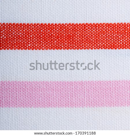 Closeup of colorful red pink white horizontal striped fabric textile as background texture or pattern. Macro.