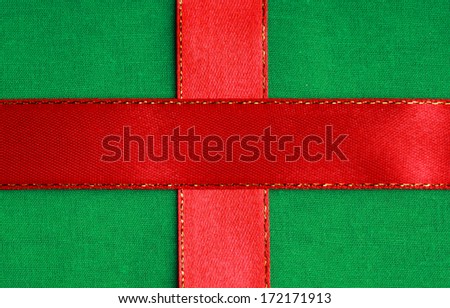 Empty banner on textile background. Red ribbon on green fabric cloth texture