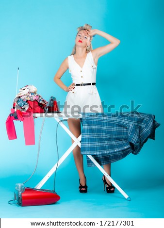Full Length Sexy Girl Retro Style Ironing Male Shirt, Woman Housewife In Domestic Role. Traditional Sharing Household Chores. Pin Up Housework. Vivid Blue Background