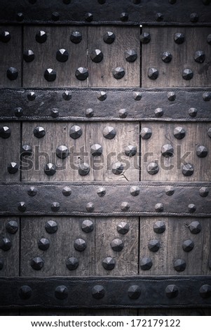 Vintage grunge wooden background door gate of the old castle detail with metal rivets