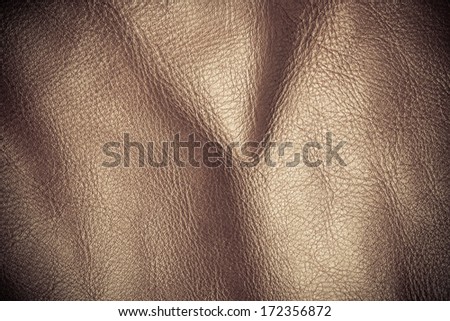 Brown leather texture background closeup. Folds wavy natural skin material