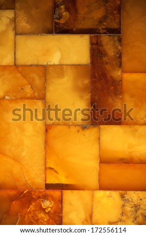 Macro. Closeup of amber mosaic as background texture or backdrop. Golden resin gem.