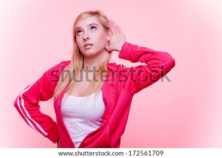 Sport fit  fitness woman with hand to ear listening pink background. Gossip