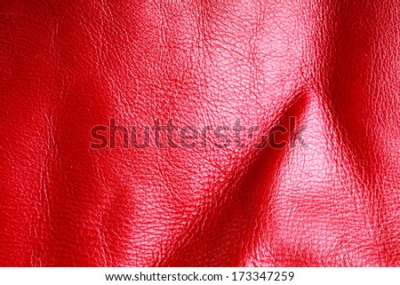 Red leather texture background close-up. Folds, wavy, natural skin, material.