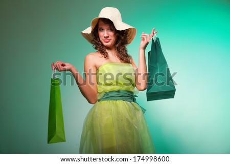 young spring woman fashion girl with green shopping bags on green background