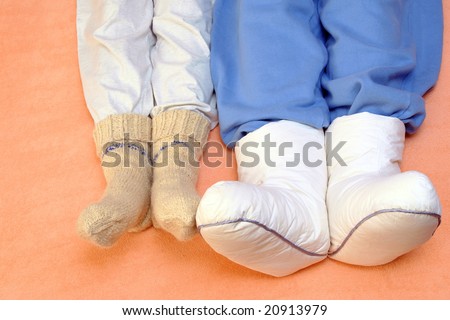 Two Couple\'s feet warming at a bed