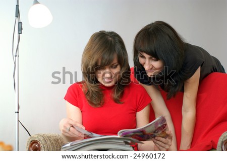 young two women in reading magazine. Reading at home