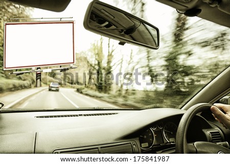 Blank white billboard with space for your advertisement seen from the inside of a car