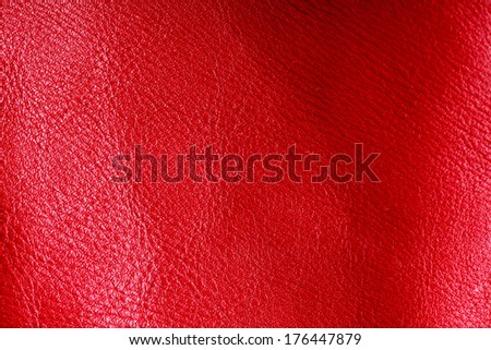 Red leather texture background closeup. Folds wavy natural skin material