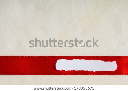 Piece scrap of white torn or ripped paper banner, blank copy space for text message red ribbon bright cloth background.