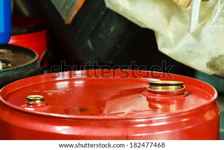 Car servicing  oil change. Red oil barrel canister in mechanic garage auto service or shop. Industry detail.