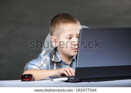 Computer addiction child boy with laptop notebook black background