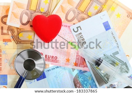 medical treatment and high cost for health care service concept: stethoscope red heart syringe on money euro paper banknotes