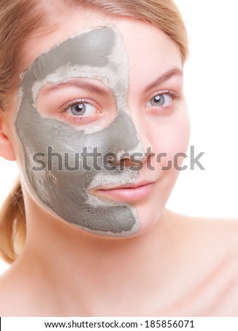 Skin care. Young woman applying clay mask on her face. Girl taking care of her dry compexion. Isolated. Spa and beauty treatment.
