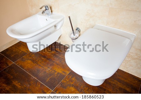 Hygiene and physiological needs. Closeup of white porcelain bidet and toilet wc. Interior of bathroom.
