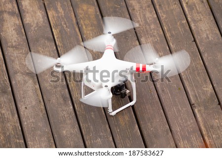 GDANSK, POLAND MARCH 01, 2014: professional drone of Quadrocopter Phantom with movie camera on wooden background. Technology innovation.
