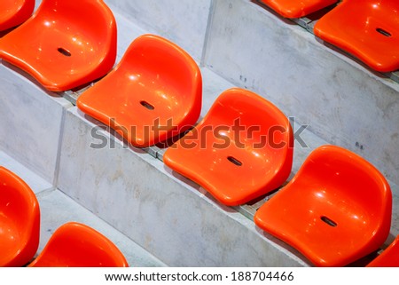 Closeup of red sport stadium seats. Empty stand. Team sport and football supporters fans.