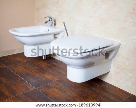 Hygiene and physiological needs. Closeup of white porcelain bidet and toilet wc. Interior of bathroom.