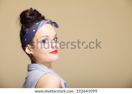 Portrait of young beautiful girl retro style fancy make-up hair bun brown background